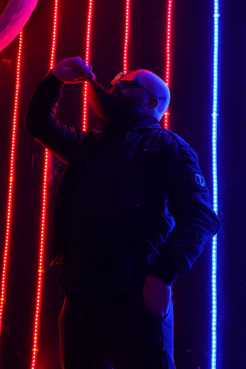 Superfoodman alias Mickael Bouchisse sous des néons rouges et bleus, en pleine mise en scène